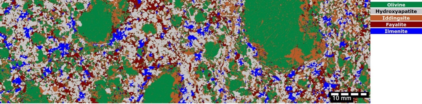 Automated mineral-phase classification map identifies olivine, fayalite, iddingsite, ilmenite, and hydroxyapatite, linking elemental zonation to specific mineral hosts.
