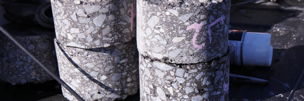 Concrete core samples showing coarse aggregate and cementitious matrix removed from a structural component for laboratory analysis.